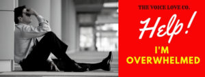 A man sits against the wall on the floor of a long hallway with his face in his hands. The Voice Love Co presents Help! I'm Overwhelmed. Learn the things you CAN change in the midst of the things you can't here.