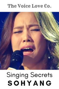 Sohyang sings into a microphone. The Voice Love Co. presents Singing Secrets of Sohyang. 